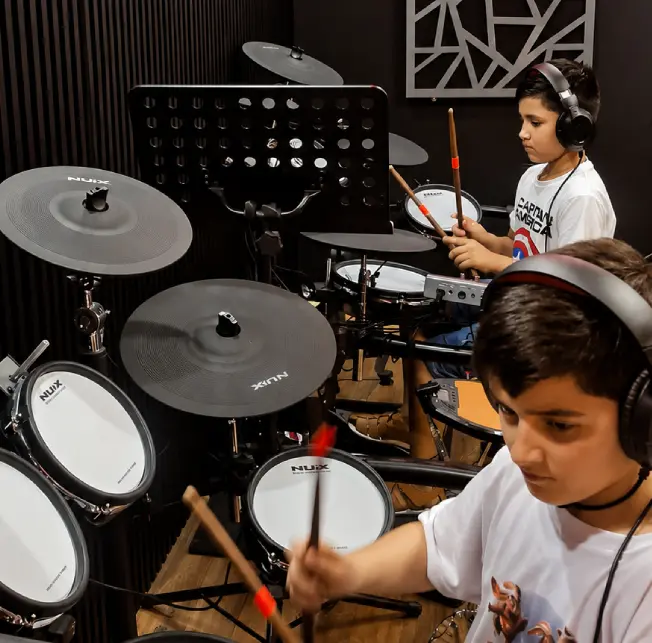 Niños en clases de batería en la academia de música BigDrummers