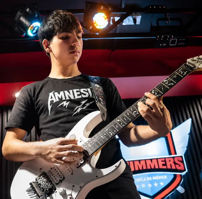 Alumno en clases de guitarra eléctrica en el escenario de la academia
